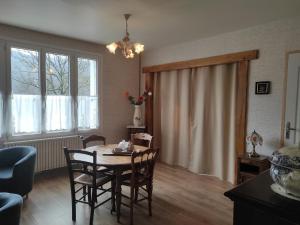 a dining room with a table and chairs in a room at La Lisière Appartement 2 chambres in Revin