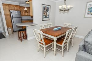 een keuken en eetkamer met een houten tafel en stoelen bij Dolphin Point 303A condo in Destin