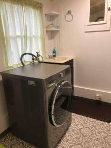 a washing machine in a bathroom with a sink at Charming Cottage in Henderson Center in Eureka