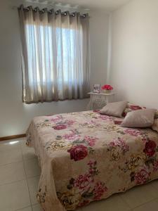 塞拉的住宿－JacaraipeTop，一间卧室配有一张带鲜花毯子的床
