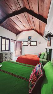 a bedroom with a red bed and green sheets at MAGNOLIAS in Antigua Guatemala