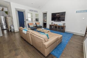 een woonkamer met een bruine bank en een blauw tapijt bij Resting Beach Place home in Destin