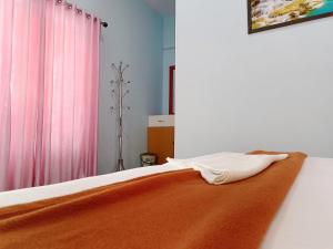 Un dormitorio con una cama con una manta naranja. en Marari Phoenix Beach Front Homestay, en Mararikulam