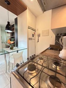 a kitchen with a stove and a counter top at L209 Apto em resort beira lago com TV Smart in Brasilia