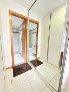 a bathroom with a walk in shower and a mirror at L209 Apto em resort beira lago com TV Smart in Brasília