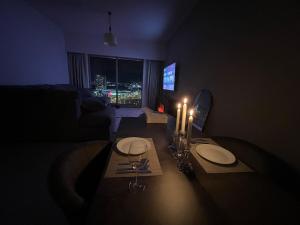 una sala de estar con una mesa con velas. en Dinar Home, en Abu Dabi