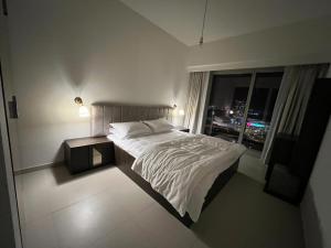 a bedroom with a large bed and a window at Dinar Home in Abu Dhabi