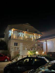 a house with a car parked in front of it at night at Apartmani Vesić in Tivat