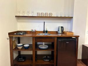 a kitchen with a counter with a sink and glasses at Villa Salento Boutique Apartments & Spa in Salento