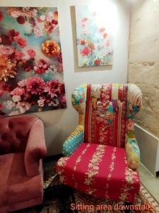Zimmer mit einem Stuhl und einem Gemälde in der Unterkunft "Spirit of Malta" Historic Maltese Townhouse by the sea in Sliema