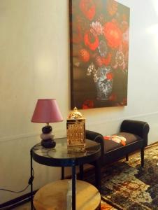 a living room with a table with a lamp and a couch at "Spirit of Malta" Historic Maltese Townhouse by the sea in Sliema