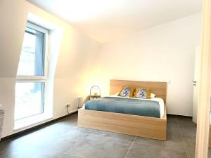 a bedroom with a bed and a large window at Penthouse 3 bedrooms in center w. private garden in Luxembourg
