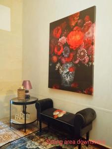 una sala de estar con una pintura de flores en la pared en "Spirit of Malta" Historic Maltese Townhouse by the sea en Sliema