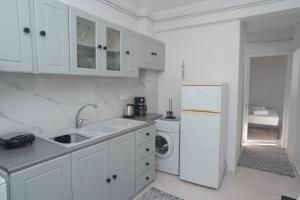 uma cozinha branca com um lavatório e um frigorífico em Alonaki home em Mesaíon Karlovásion