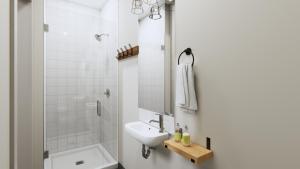 y baño blanco con lavabo y ducha. en Basecamp Suites Revelstoke en Revelstoke
