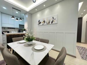 a dining room with a white table and chairs at Sunset View at Modern Home in Kuala Lumpur