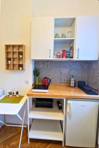 a kitchen with a wooden counter top and white cabinets at Cozy ensuite room in Zagreb center in Zagreb