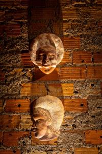 Un mur avec une statue d'un visage sur lui dans l'établissement Pousada O Canto do Francês, à Soure