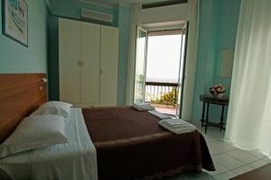 una camera con un grande letto e una finestra di acapulco hotei a Rimini