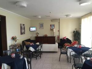 a living room with tables and chairs and a couch at acapulco hotei in Rimini