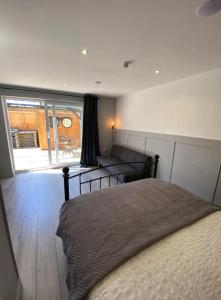 1 dormitorio con cama, sofá y ventana en The Studios en Hempstead