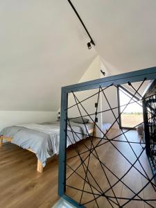 um quarto com uma cama e uma janela de vidro em Nowoczesny, komfortowy domek z balią, kominkiem, ogniskiem, grillem em Benenard