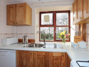 a kitchen with a sink and a window at The Stables in Llandyfrydog