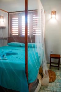 a bedroom with a blue bed with a canopy at Casa FLOREAL Icaraizinho de Amontada wifi in Icaraí +35 photos