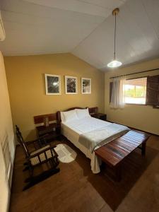 1 dormitorio con cama y banco. en Hotel Fazenda Brejo, en Saloá