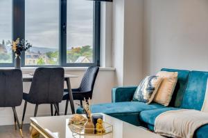 uma sala de estar com um sofá azul e cadeiras em ENTERPRISE APARTS em Bradford