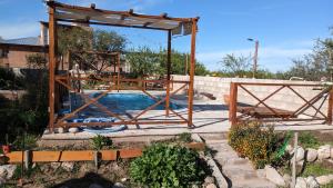 einen Pool in einem Garten mit einem Holzpavillon in der Unterkunft Aires de la Quebrada in Quebrada de los Pozos