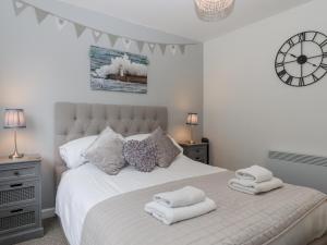 Un dormitorio con una cama blanca con toallas. en 3 Dolphin Court, en Brixham