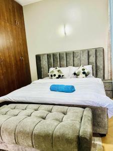1 cama grande con 2 almohadas de fútbol en Cyda Orchid Home-Buziga-Munyonyo, en Kampala