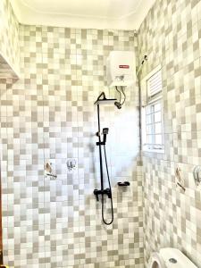 y baño con ducha con cabezal de ducha. en Cyda Orchid Home-Buziga-Munyonyo, en Kampala