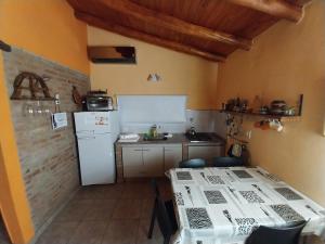 eine Küche mit einem weißen Kühlschrank und einem Tisch in der Unterkunft Aires de la Quebrada in Quebrada de los Pozos