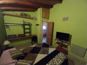 Schlafzimmer mit einem Bett, einem Schreibtisch und einem TV in der Unterkunft Aires de la Quebrada in Quebrada de los Pozos
