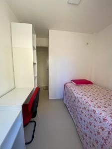 um quarto com uma cama e uma parede branca em Casa 02 - Aconchego em Caucaia