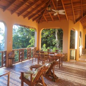 a room with a table and chairs on a balcony at La Hacienda Belize Guest House in Benque Viejo del Carmen