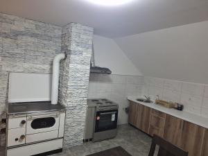 cocina con fogones y pared de ladrillo en Apartman Danica Foča, en Foča