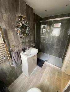 a bathroom with a white sink and a shower at The Studios in Hempstead