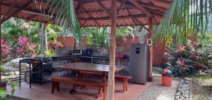 eine Außenküche mit einem Tisch und einem Herd in der Unterkunft las cabinas del sueño in Nicoya