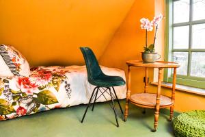 Kockengen的住宿－BoHo Experience Wellness, Jacuzzi, Sauna, BBQ, Garden, Sleeps 10，卧室配有1张床、1张桌子和1把椅子