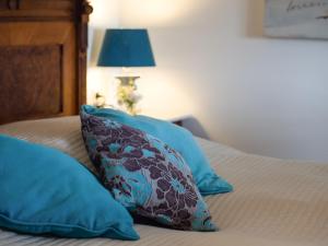 a bed with two blue pillows and a lamp at Hotel Burg Abenberg in Abenberg