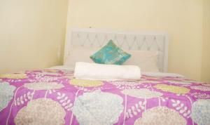 ein lila und weißes Bett mit zwei Kissen darauf in der Unterkunft Fully furnished One bedroom bnb in Thika Town. in Thika
