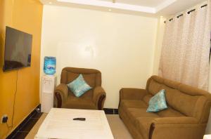 sala de estar con 2 sillas y sofá en Fully furnished One bedroom bnb in Thika Town. en Thika