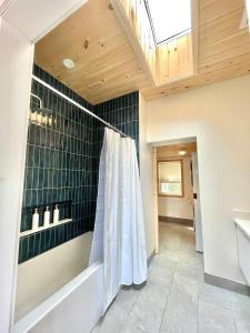 y baño con ducha y bañera. en Modern waterfront cottage +hot tub, en Marion Bridge