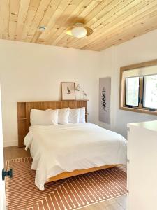 a bedroom with a large bed with a wooden headboard at Modern waterfront cottage +hot tub in Marion Bridge