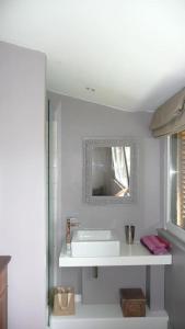 ein weißes Badezimmer mit einem Waschbecken und einem Spiegel in der Unterkunft Maison d'architecte idéalement située pour les JO in Neauphle-le-Château