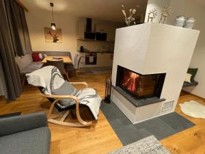 a living room with a fireplace in the middle at Luxusapartment mit Sauna am Berg in Sankt Ulrich am Pillersee