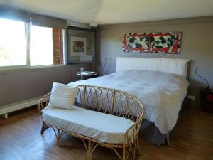 ein Schlafzimmer mit einem weißen Bett und einem Stuhl in der Unterkunft Maison d'architecte idéalement située pour les JO in Neauphle-le-Château